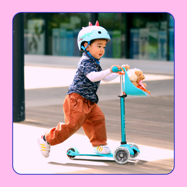 A young boy rides the Micro Mini LED Scooter outside.
