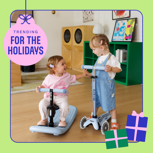 Two girls smile at each other while each riding Micro Mini Rock & Go LED. 